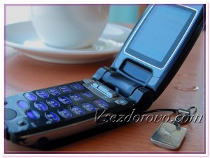 Мобильный телефон и чашка кофе на столе в кафе