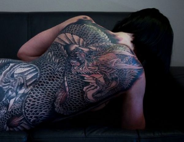 Татуировка дракона у девушки на груди