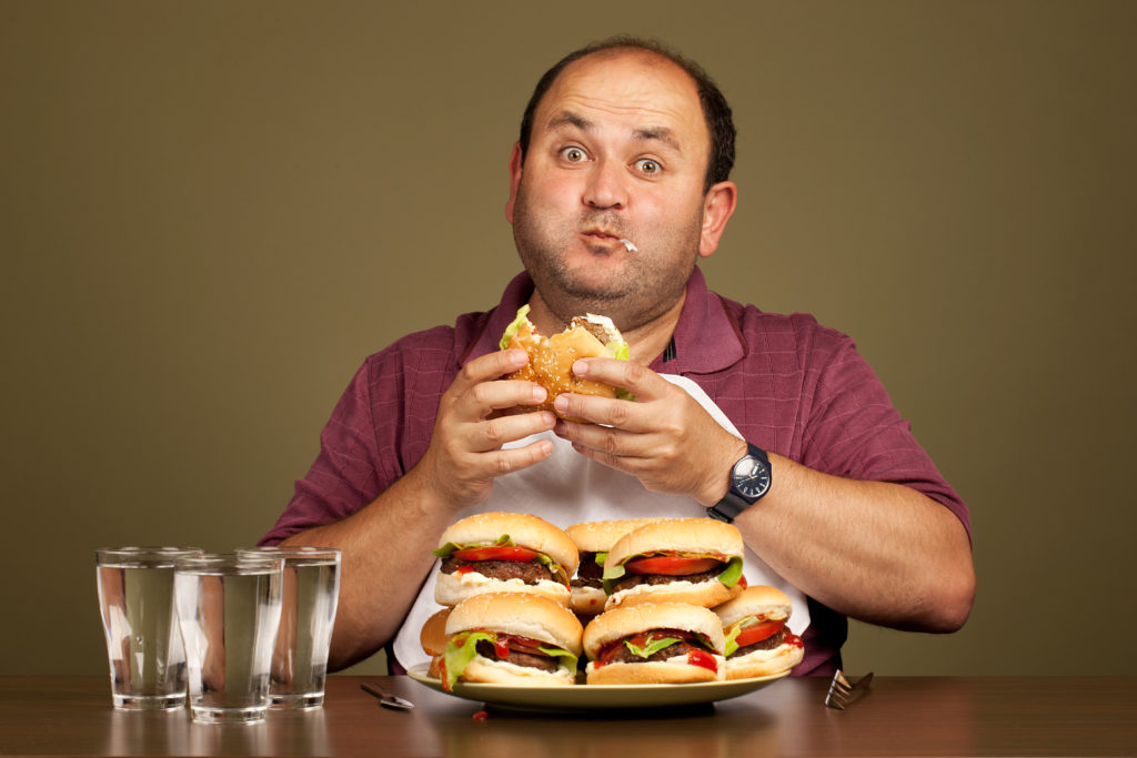 Man eating many burgers.
